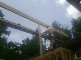 Carpenter setting a ridge beam over a new addition frame — Ice Dam Removal by Roofing Brothers in Aaronsburg