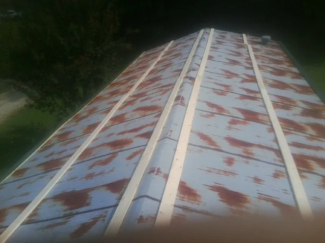 Rusted metal roof panels with new wood purlins before replacement — Storm Damage Roof Repair in Aaronsburg by Roofing Brothers
