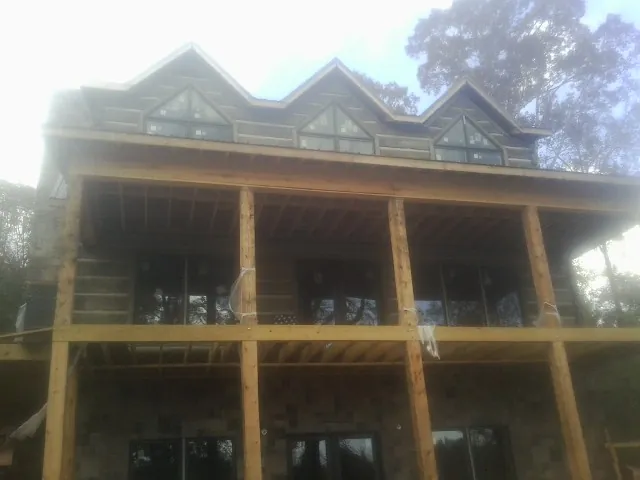 Dormers and porch framing on a large log home under construction — Roof Coating work by our crew in Aaronsburg