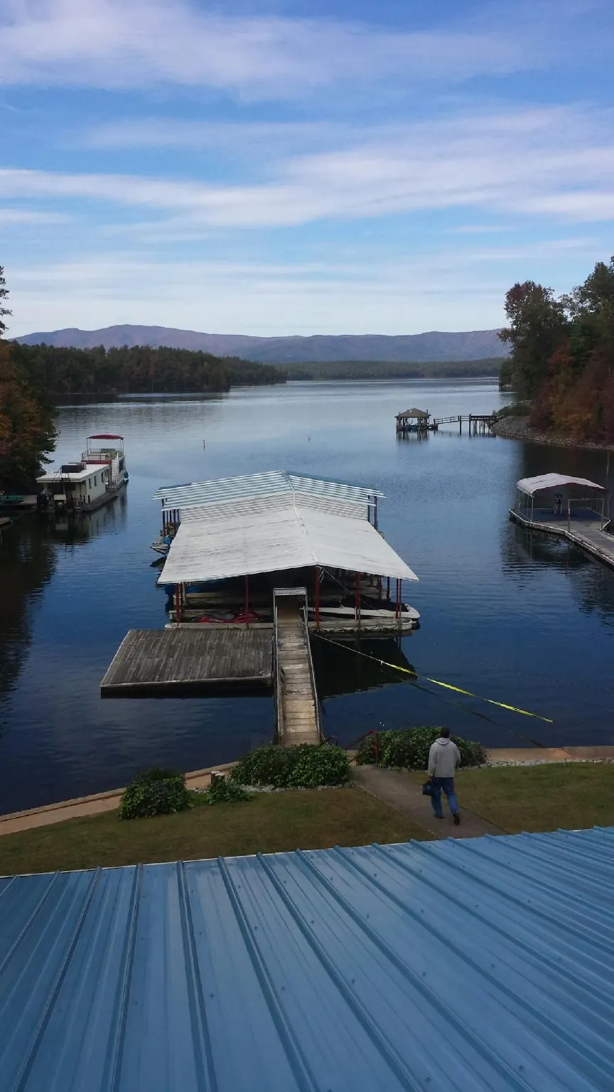 View across a lake from a newly installed blue metal roof in Aaronsburg