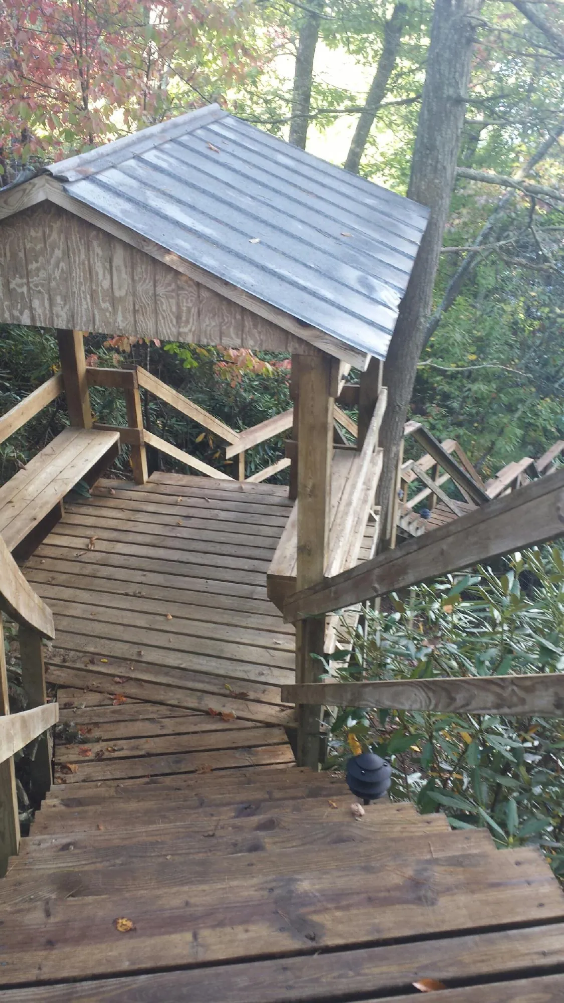 Metal roofed shelter over wooden steps on a wooded walkway — Skylight Repair & Installation work by our crew in Aaronsburg