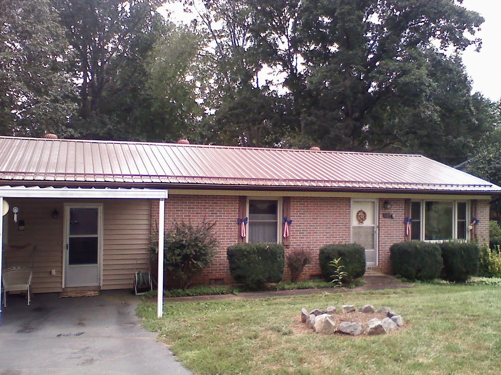 Bronze metal roof and carport on a brick ranch home — Roof Repair work by our crew in Aaronsburg